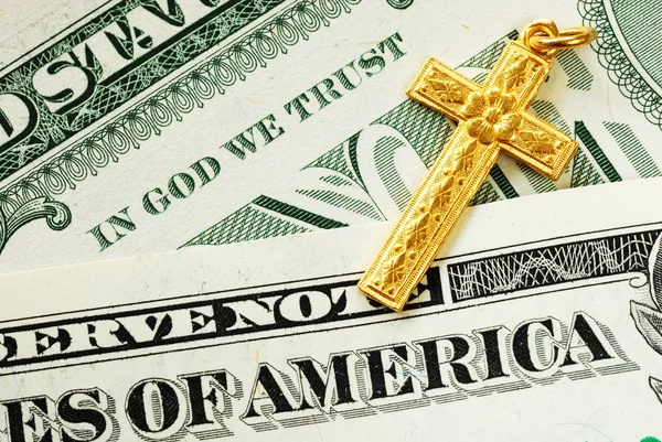 Uma cruz de ouro no conceito de notas de dólar de In God We Trust — Fotografia de Stock