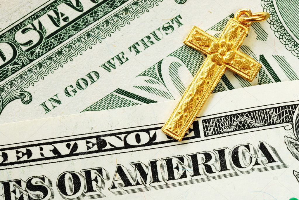 A golden cross on the dollar bills concept of In God We Trust
