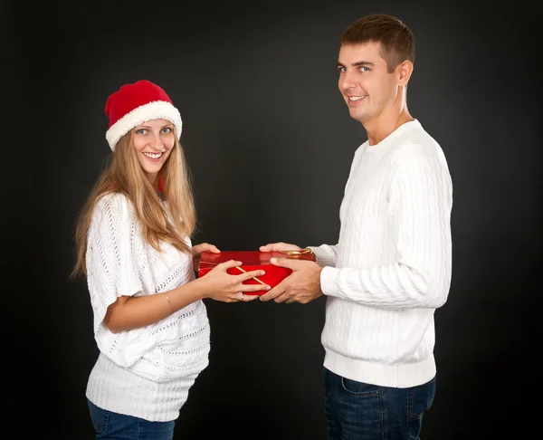 The man gives the gift pregnant girl in Santa hat — Stock Photo, Image