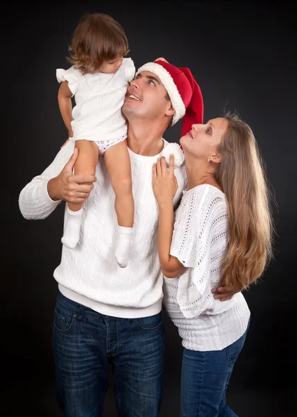 Familia sobre fondo negro, sombrero de Papá Noel con papá . —  Fotos de Stock