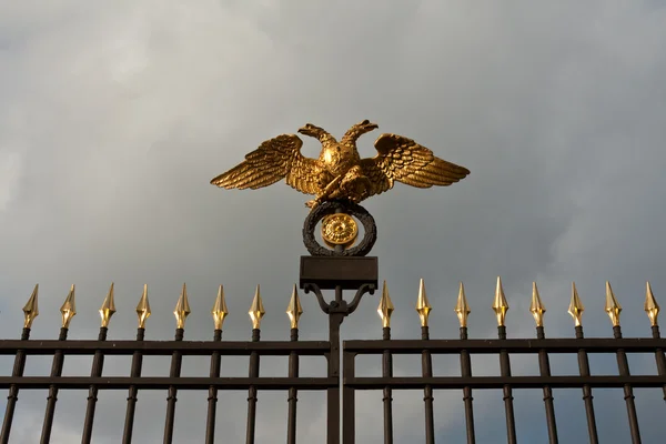 Águia dupla de ouro em uma cerca de aço — Fotografia de Stock