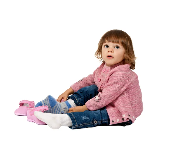 Little girl wears shoes on a white floor — Stock Photo, Image