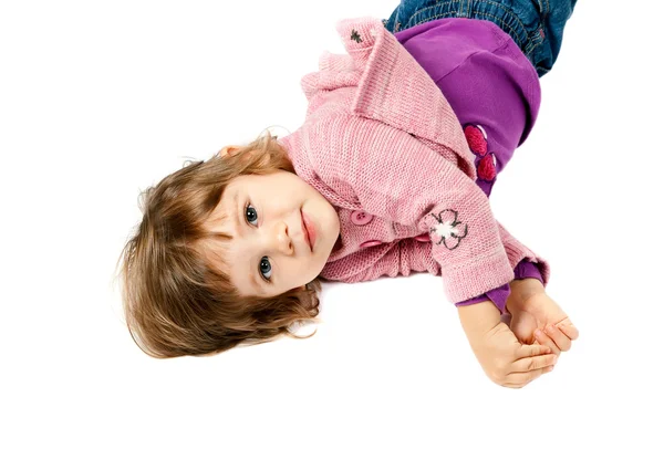 Маленькая девочка лежит на белом полу — стоковое фото