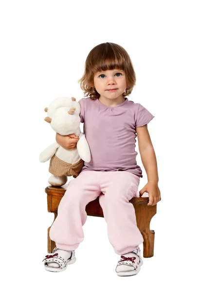 Meisje, zittend op een houten kruk — Stockfoto