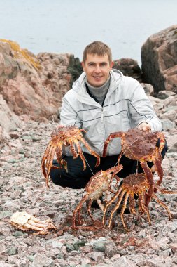 Man with crabs in the Barents Sea coast clipart