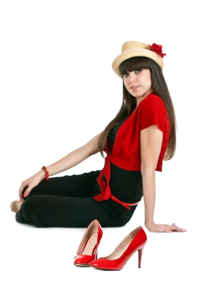 Hermosa chica en el fondo de un par de zapatos de mujer rojos . — Foto de Stock