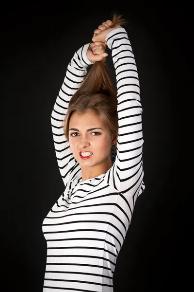 Beautiful girl in a striped dress pulls his hair — Stock Photo, Image
