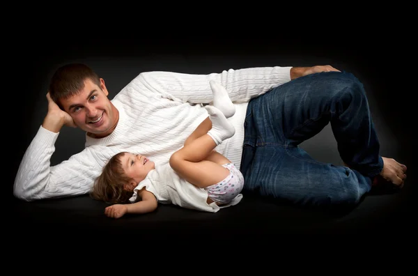 Šťastný otec se svou malou dcerou ležící — Stock fotografie