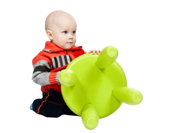 Little boy with a plastic chair in the studio Stock Image