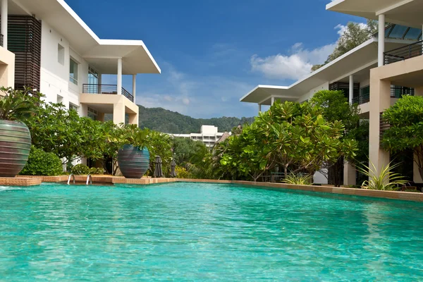 Отель с голубым бассейном с пальмовыми деревьями — стоковое фото