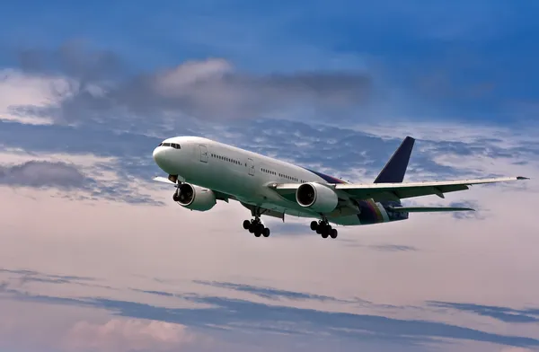 Avión de pasajeros viene a aterrizar en un cielo azul — Foto de Stock
