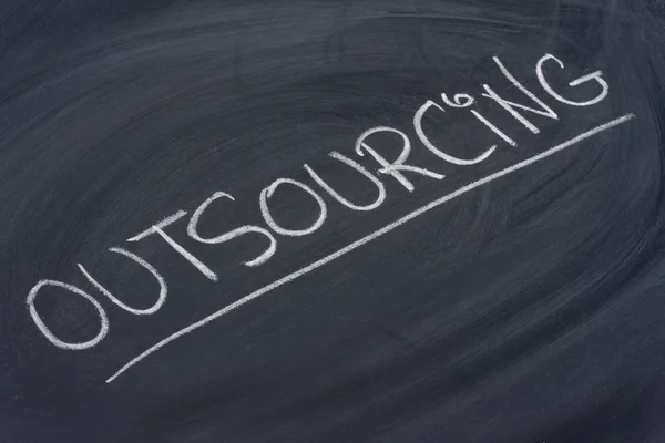 Outsourcing woord op blackboard — Stockfoto