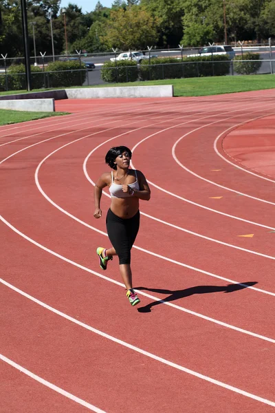 Regordete joven negro mujer corriendo en pista — Foto de Stock