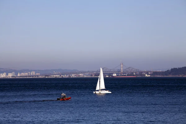 Velero catamarán y zodíaco en la bahía — Foto de Stock