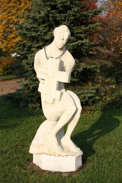 Escultura de un hombre con una cruz — Foto de Stock