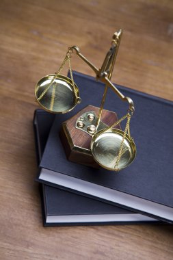 Scales of justice and gavel on desk with dark background