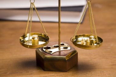 Scales of justice and gavel on desk with dark background