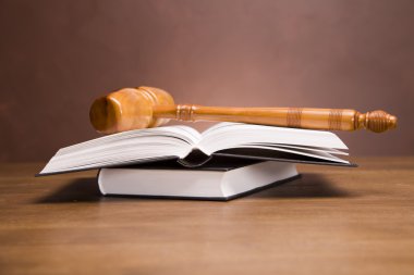 Scales of justice and gavel on desk with dark background