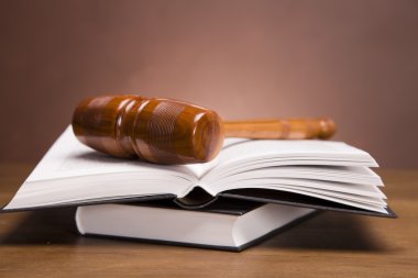 Scales of justice and gavel on desk with dark background