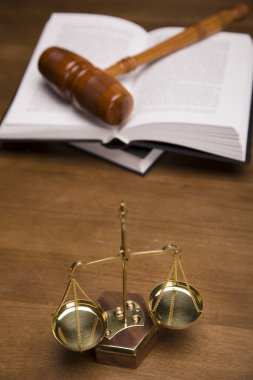 Scales of justice and gavel on desk with dark background