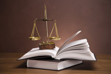 Scales of justice and gavel on desk with dark background