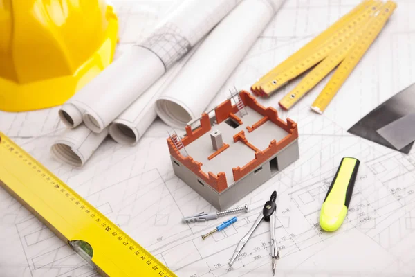 Planes de construcción con casco y herramientas de dibujo en planos — Foto de Stock