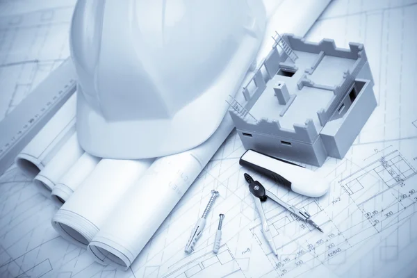 Construction plans with helmet and drawing tools on blueprints — Stock Photo, Image