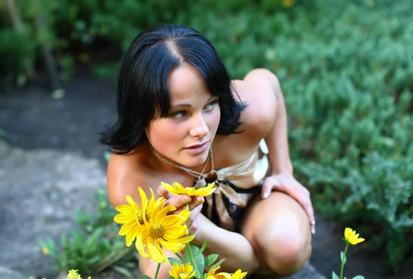 Sexy Model im Park mit Blumen — Stockfoto