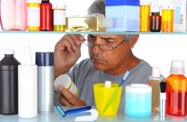 Middle aged man in front of medicine cabinet clipart