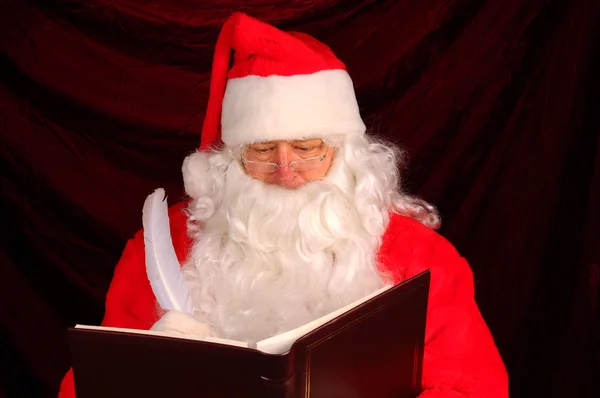 Weihnachtsmann mit frechen und schönen Buch — Stockfoto