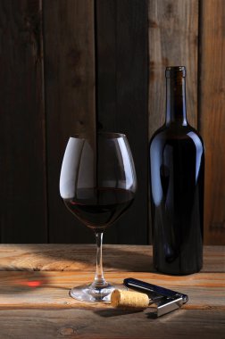 Wine bottle and wineglass in cellar setting clipart