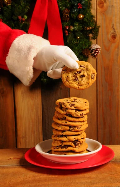 Weihnachtsmann nimmt Kekse vom Teller — Stockfoto