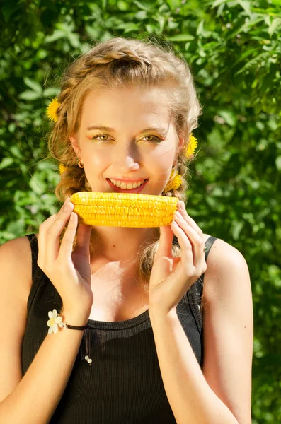 Женщина ест кукурузный початок — стоковое фото