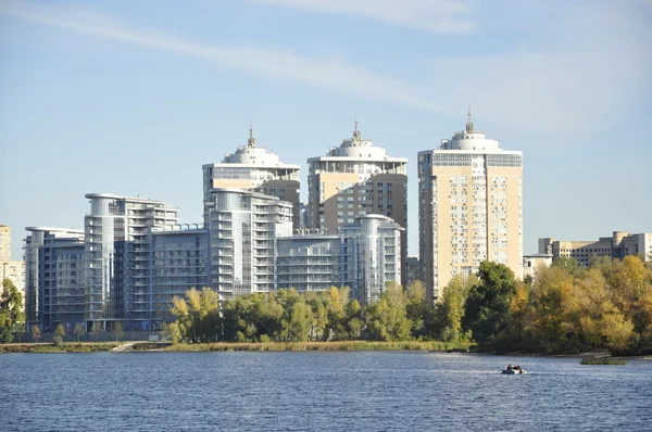 Tre höga byggnader på stranden av floden — Stockfoto