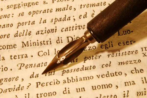 Nib (pen) over an old book — Stock Photo, Image