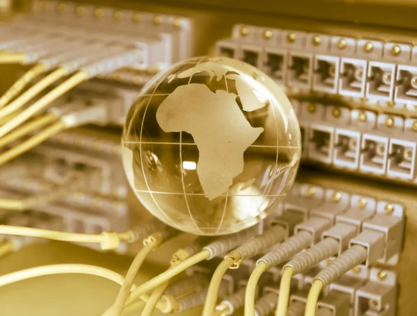 Globus z kabli sieciowych i serwerów w centrum danych technologii — Zdjęcie stockowe