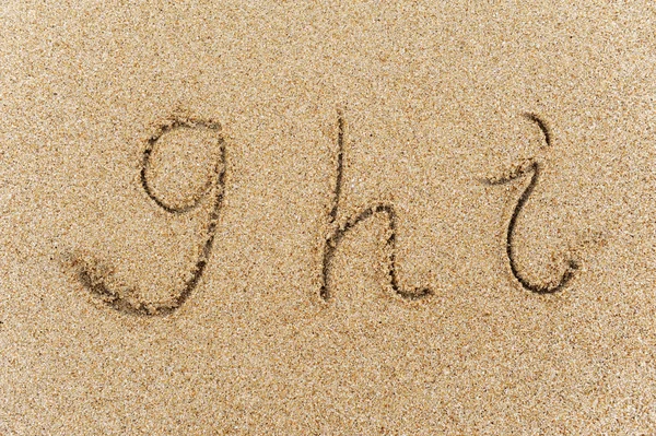 Alfabe harfleri kumsalda el yazısıyla yazılmış. — Stok fotoğraf