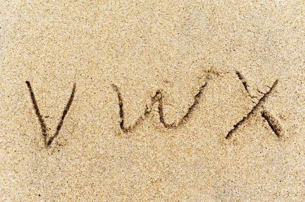 Ábécé betűk kézzel írt homok a strandon — Stock Fotó