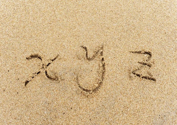 Letras del alfabeto escritas a mano en arena en la playa —  Fotos de Stock