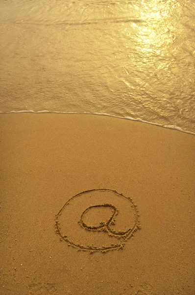 Рисунок электронного символа на пляже — стоковое фото