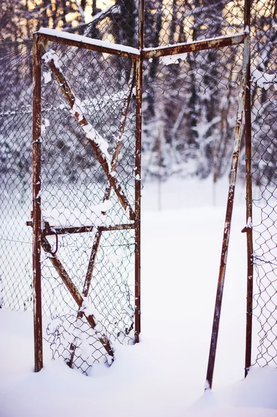 Kaputter Zaun unter Schnee Stockbild