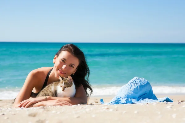 女孩在沙滩上和一只小猫 免版税图库图片