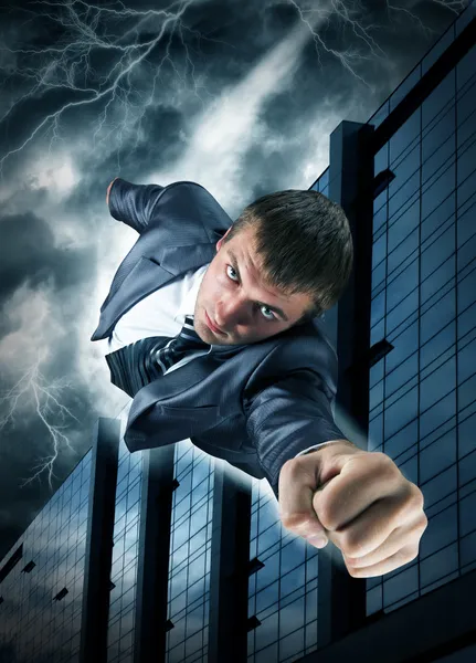 Супергеройский бизнесмен, летящий над центром города — стоковое фото