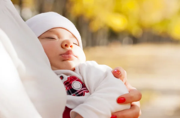Спящая маленькая девочка на руках матери — стоковое фото
