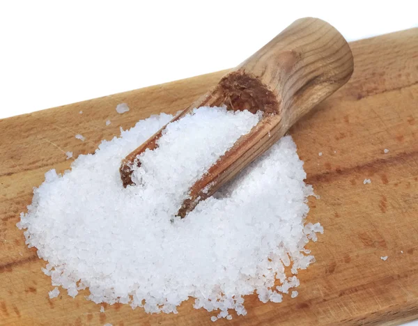 Salt on wooden board with spoon — Stock Photo, Image