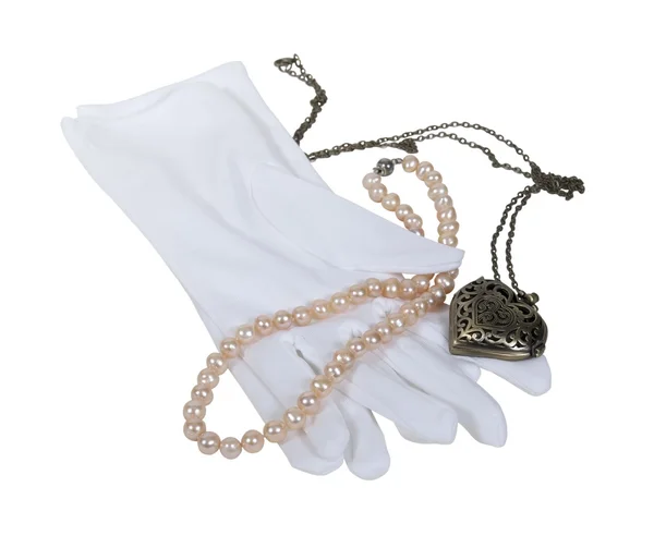 Vita handskar med pärlor och hjärtat medaljong — Stockfoto