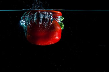 Pepper dropped into water. clipart