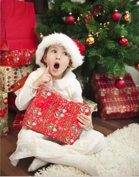 Niño con regalo delante del árbol de Navidad — Foto de Stock