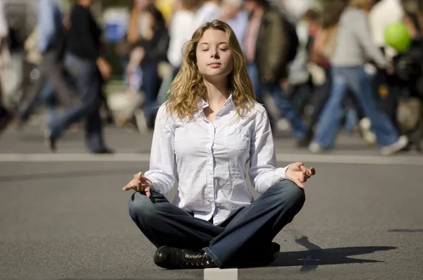 Woman meditating in busy urban street — Stock Photo, Image