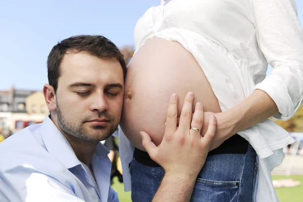 Mann küsst schwangeren Bauch seiner Frau — Stockfoto